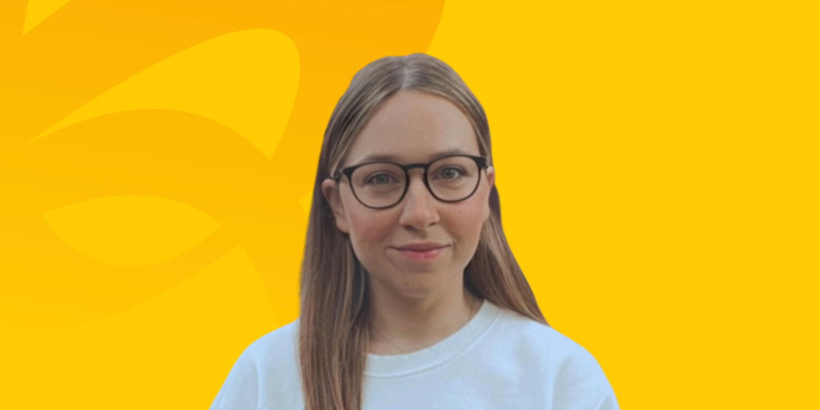 The image shows Sena, our Growth Executive here at Kwalee, her portrait image is placed onto a background of Kwalee branded colours of yellows. There is a slight pattern to that looks like a swirl, which is a slightly darker yellow, all in brand guidelines. Sena is wearing glasses, a white tshirt, brunette hair and staring at the camera. 